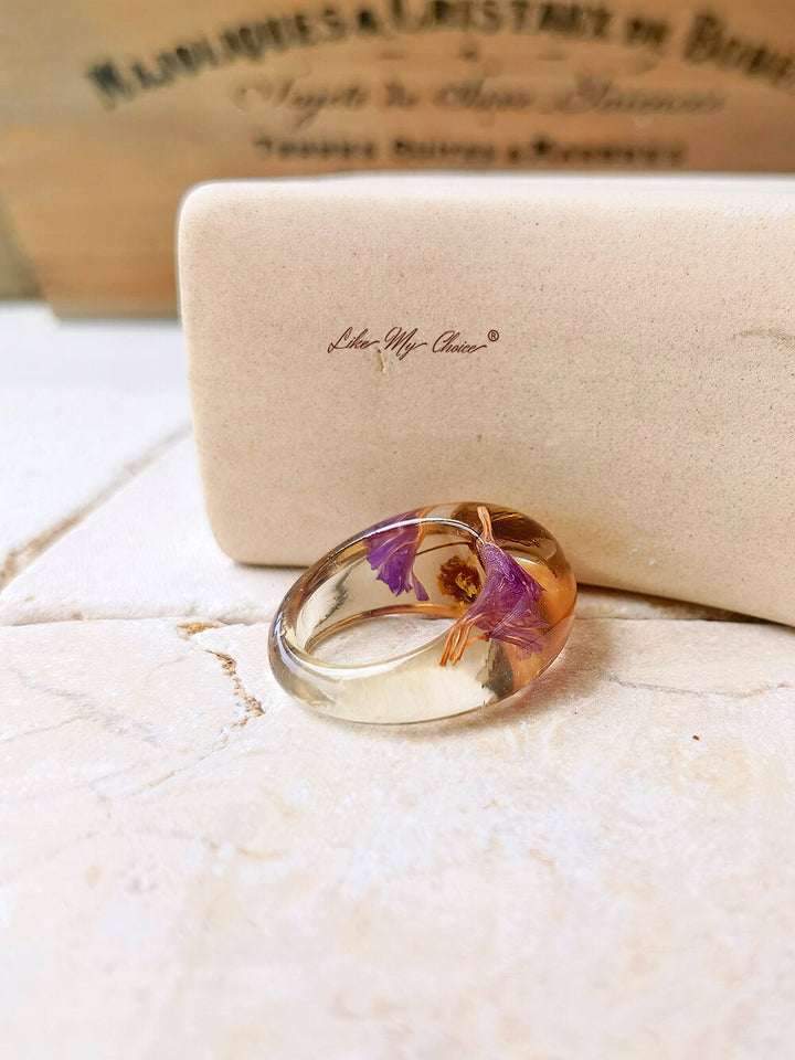 Ring aus getrocknetem Blumenharz mit lila Blüten